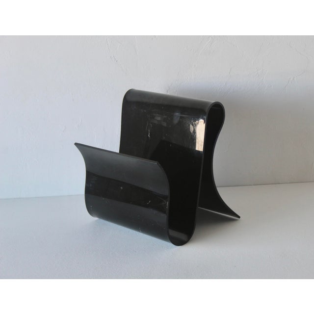 A Kartell style black acrylic magazine rack. Fabulous design evokes a wide ribbon. In good vintage condition with some...