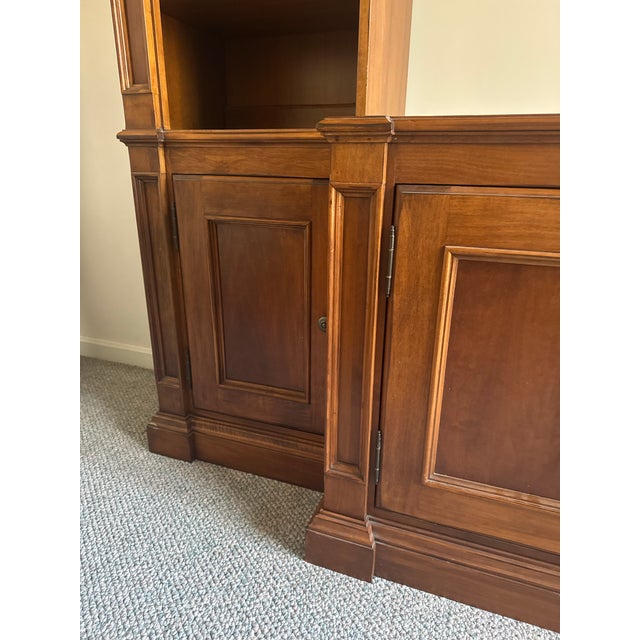 A substantial vintage Nichols & Stone Williamsburg Collection entertainment center / wall unit crafted in a rich cherry...