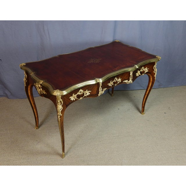 A Louis XV style marquetry desk resting on four cabriole legs with canted corners, 19th century. This desk features three...