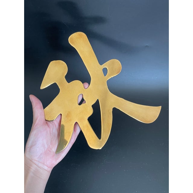 A vintage brass trivet in the form of the Chinese character for “Autumn”, a symbol often associated with maturity and...