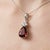 This exquisite pendant features a striking Garnet gemstone, celebrated for its deep, fiery red tones and timeless allure....