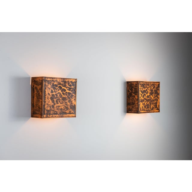 This striking pair of vintage brass wall lamps is defined by its bold, architectural form and richly textured surface....