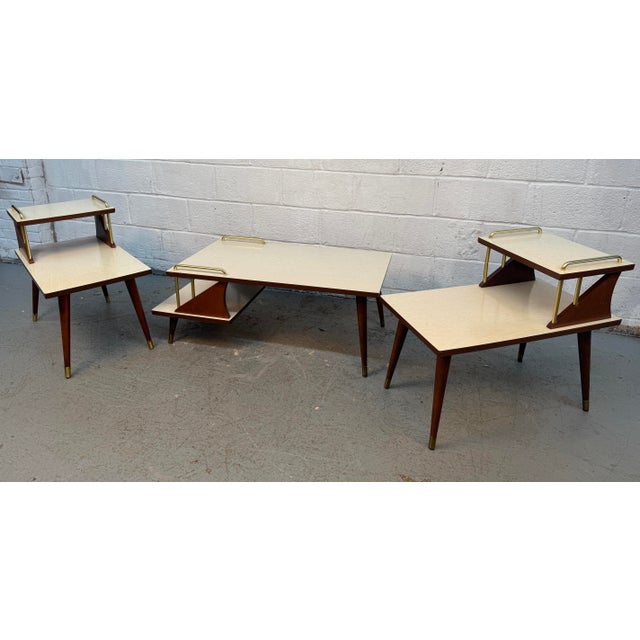 Stylish 1950s mid-century modern three-piece table set featuring a distinctive atomic-inspired tiered design. The set...
