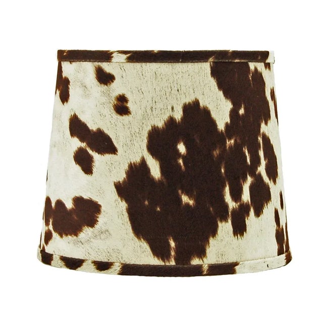 This brown faux cowhide drum lamp shade offers a rustic and western-inspired aesthetic, perfect for adding warmth and...