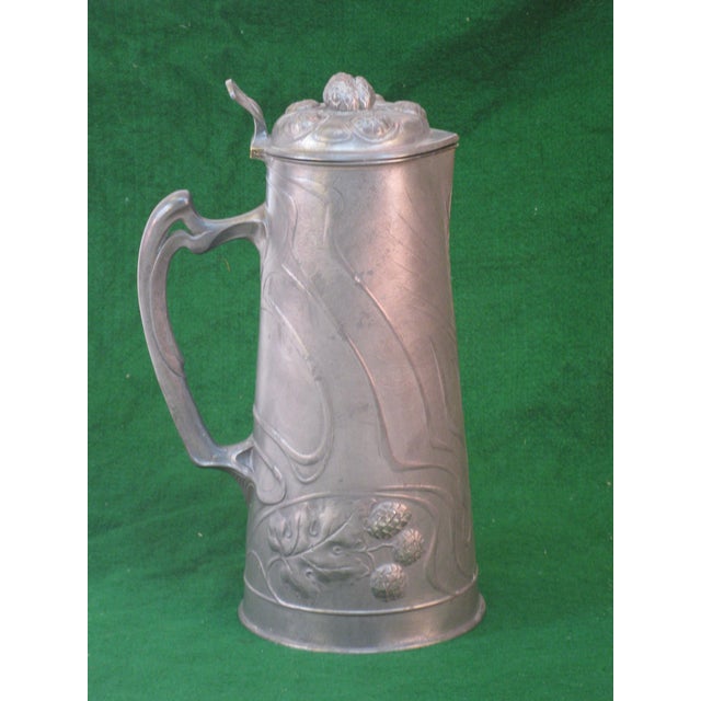 This Art Nouveau OSIRIS 601 Pewter Tankard/Pitcher is a magnificent addition to any collection of metalware. Crafted with...