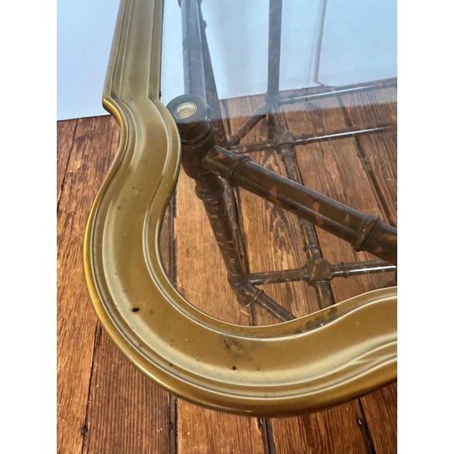 Classically designed faux bamboo base coffee table having brass trimmed glass tray top with scalloped shape.