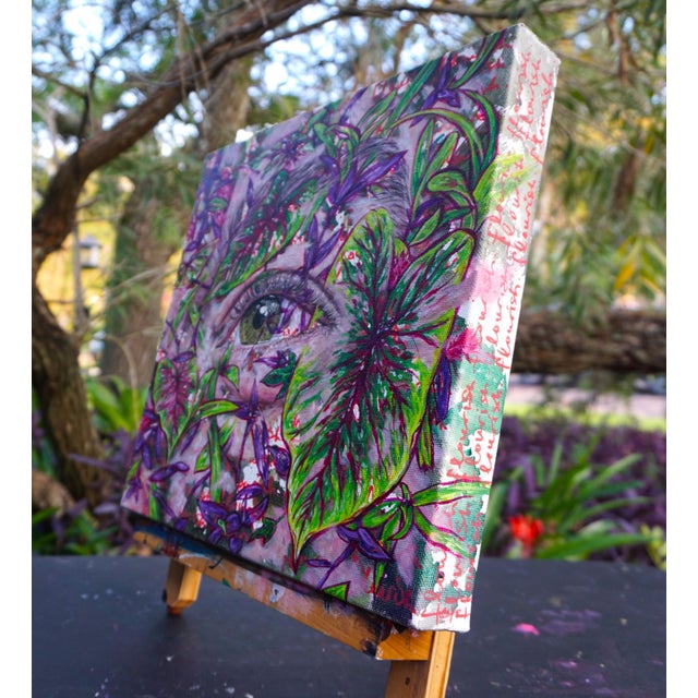 This artwork presents a close-up view of an eye partially obscured by vibrant foliage, creating an intimate connection...
