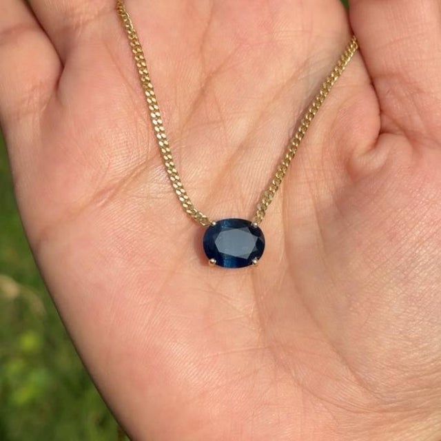 This pendant necklace features a 4.33 carat oval-cut natural blue sapphire set in 14k yellow gold. The sapphire measureing...