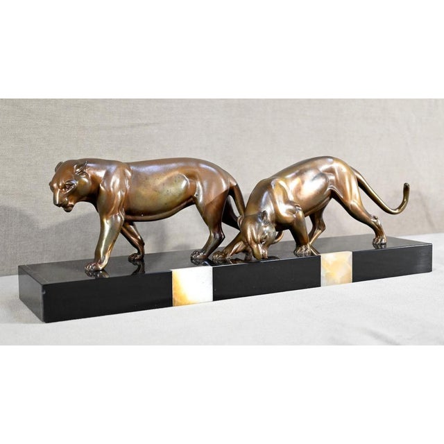 Lioness group in regula with brown, bronze and gilded patina. This figurative work represents two felines, with powerful...