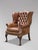 A high-quality, untouched 19th-century brown leather button back wing armchair in the George III style. The substantial,...