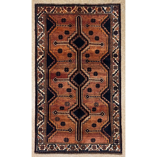 Antique hand-knotted rug from the Shiraz region of southern Iran, featuring a warm camel-brown field with a bold,...