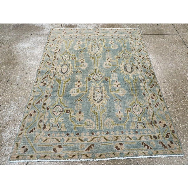 This mid-20th-century Persian Malayer throw rug presents a softly balanced floral composition across a muted blue field....