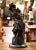 An elegant and highly decorative French bronze sculpture titled La Belle aux Jumelles, depicting a fashionable young woman...