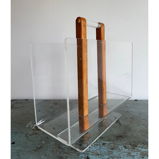 Lucite or Acrylic and Wood forms this Mid-Century Magazine Rack, attributed to Grosfeld House. The wood forming the spine...