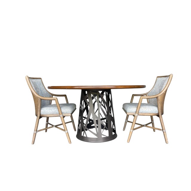 Set of four McGuire Passage dining armchairs featuring sculpted rattan frames with signature rawhide lashings and woven...