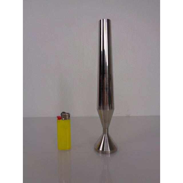 Small, minimalist vase made of satin-finished steel.