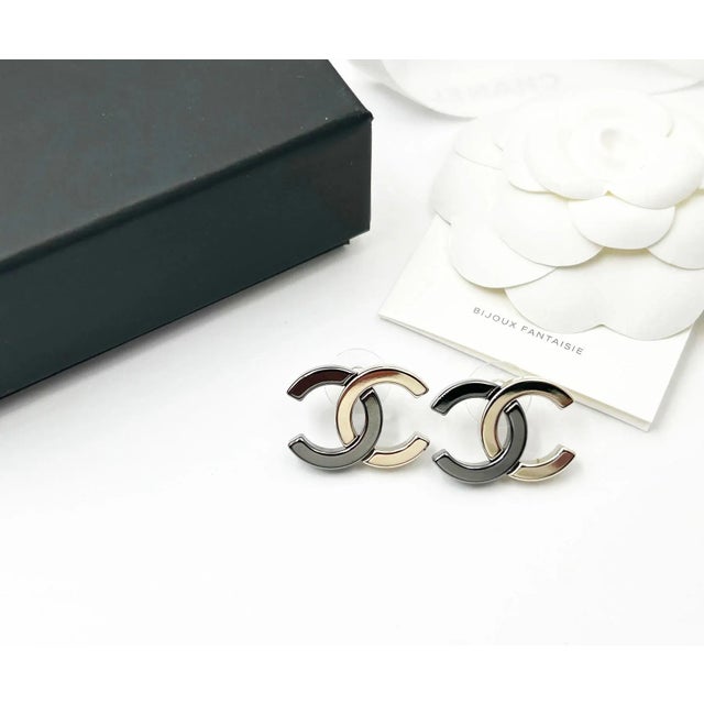 This is part of Chairish’s Costume Jewelry assortment. Chanel Brand New Gold Gunmetal CC Half Half Large Piercing Earrings...