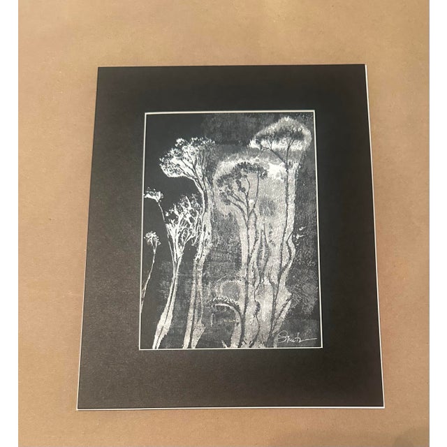 An evocative black-and-white botanical artwork depicting a delicate stand of tall, stylized botanicals. The luminous white...
