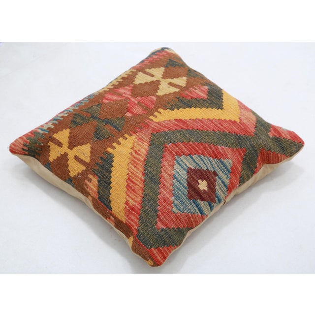 A one-of-a-kind handwoven Afghan wool kilim accent pillow featuring bold concentric diamonds in red, green, and gold. Cut...