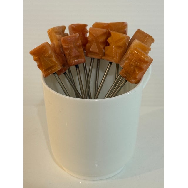 A charming set of twelve vintage cocktail forks featuring hand-carved Mexican honey onyx handles in beautiful shades of...