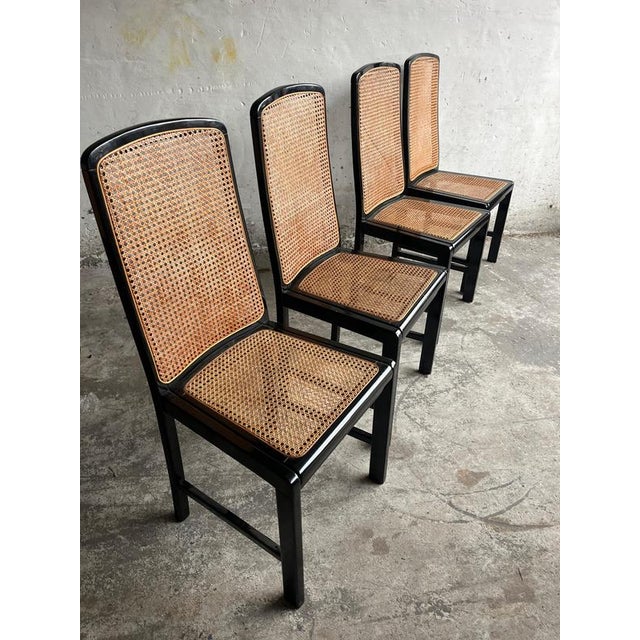 Elegant set of four vintage dining chairs from the 1980s, featuring a black lacquered wooden frame combined with natural...