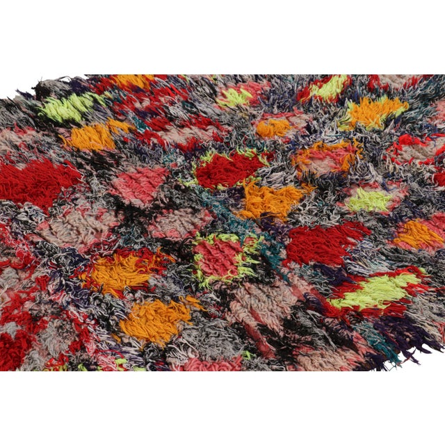 Hand-knotted in wool and originating from Morocco circa 1950-1960, this 3x7 special vintage rug features a colorful boho...