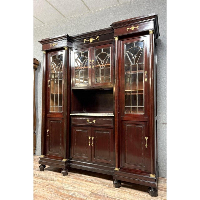 Empire style mahogany and gilt bronze display cabinet, circa 1880 (b) projected front opening with 8 doors, 4 with small...