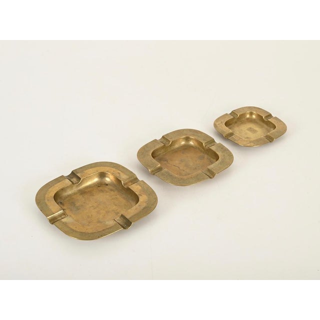 Marvelous modernist set of three interlocking ashtrays entirely made in solid brass. This refined and unique set was...
