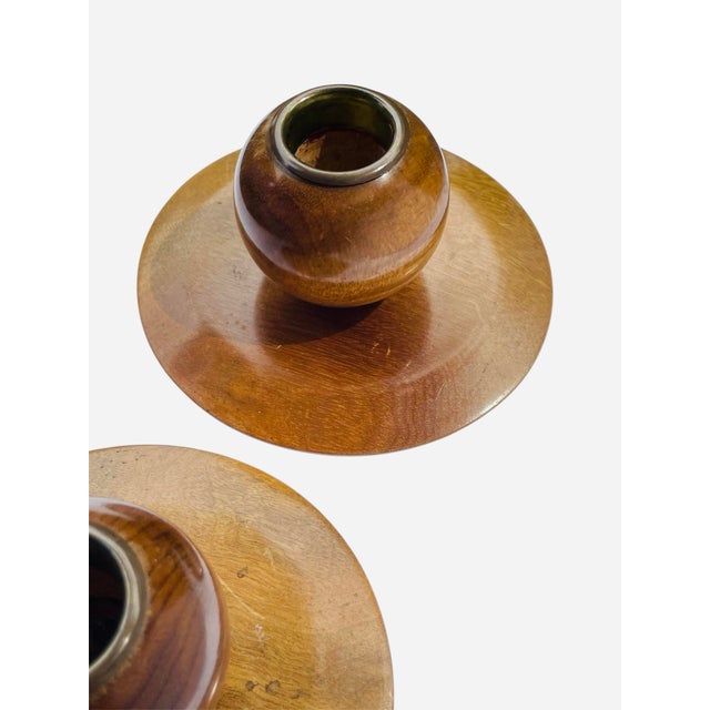 Sculptured candleholders made from myrtlewood with brass rim detail. Myrtlewood is a species of tree found on the West...