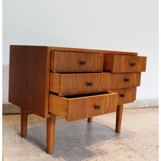 This vintage Scandinavian side table features six dovetailed drawers and discreet patinated metal handles. Crafted from...
