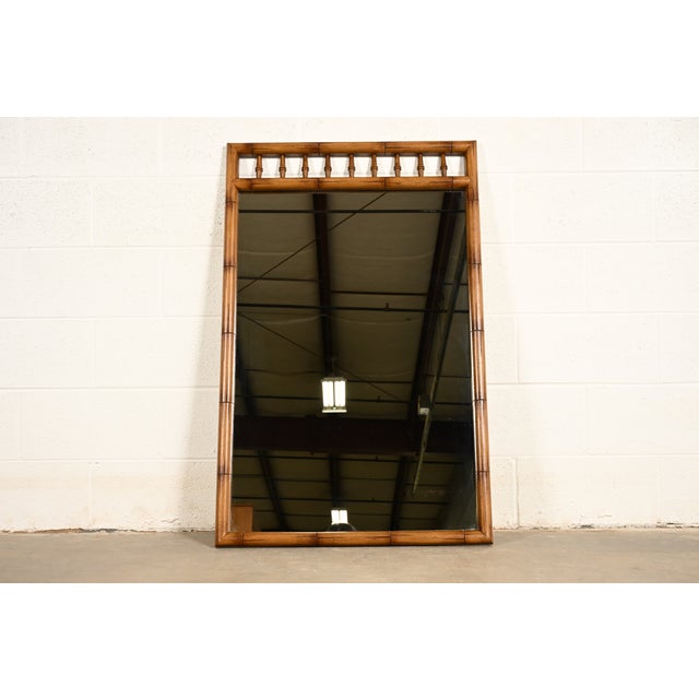 A gorgeous mid-century modern Hollywood Regency Chinoiserie sculpted walnut faux bamboo wall mirror By Thomasville USA,...