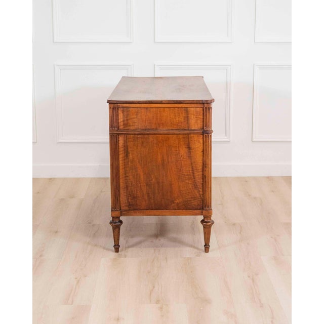 A refined French Louis XVI chest of drawers in solid walnut, dating to circa 1780, distinguished by its elegant...