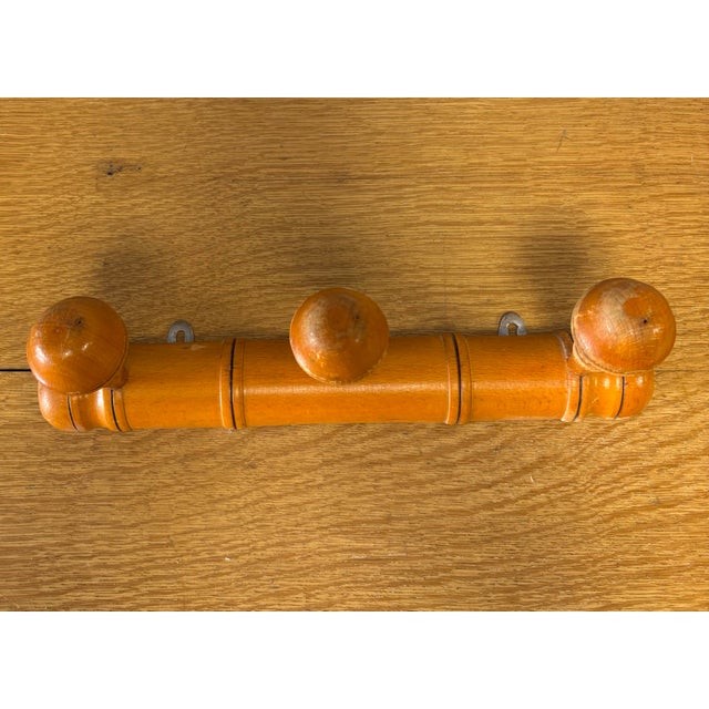 A charming vintage French wooden coat rack crafted in the classic faux bamboo style, a design long favored for its...