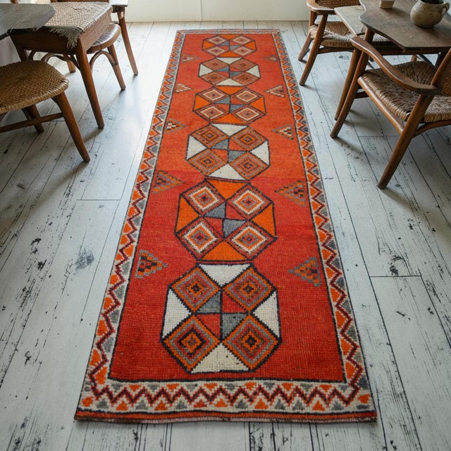 This authentic 1970s hand-knotted runner rug hails from Southeastern Anatolia, showcasing a distinct departure from...