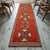 This authentic 1970s hand-knotted runner rug hails from Southeastern Anatolia, showcasing a distinct departure from...