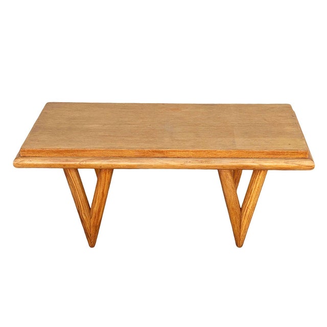 Original Mid-century blond wood coffee table with a stepped rift-sawn oak top and knife legs. It features a rectangular...