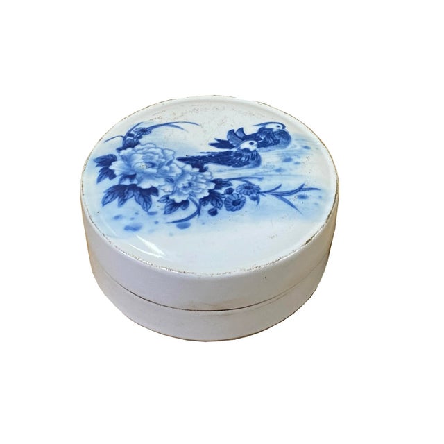 This is a Chinese decorative porcelain round box in Blue and White color finish. The theme is oriental scenery graphics....