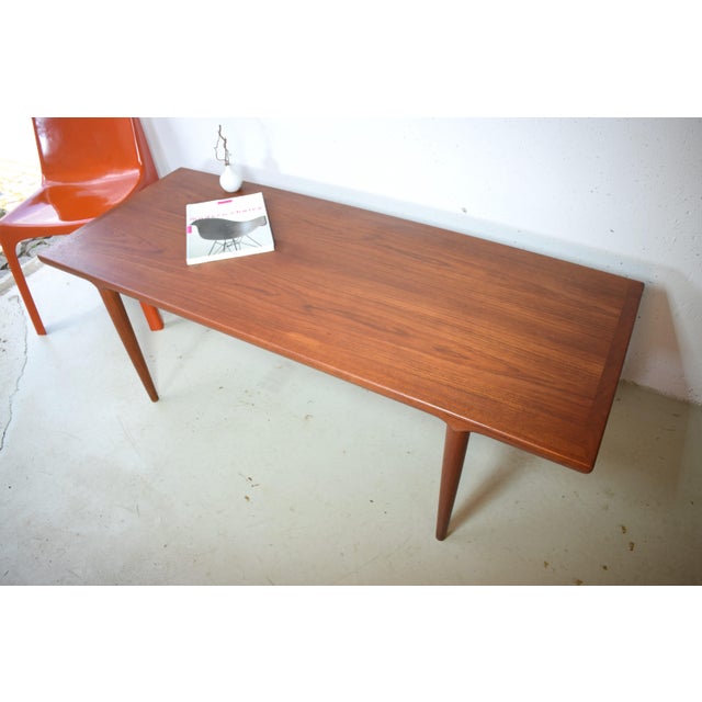 This Danish teak table from the 1960s offers ample space for various favorite items. The elegant legs and tabletop are...