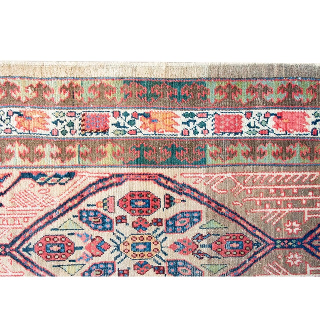 This antique Persian Serab runner, dating to the early 20th century, features a classic camel-colored field adorned with a...