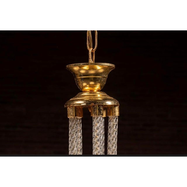 This elegant five-light chandelier balances polished brass hardware with intricate glasswork. At its core is a vertical...