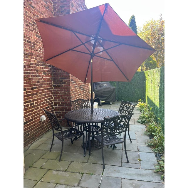 A vintage vintage cast aluminum patio set showcases traditional craftsmanship with beautifully carved floral details...