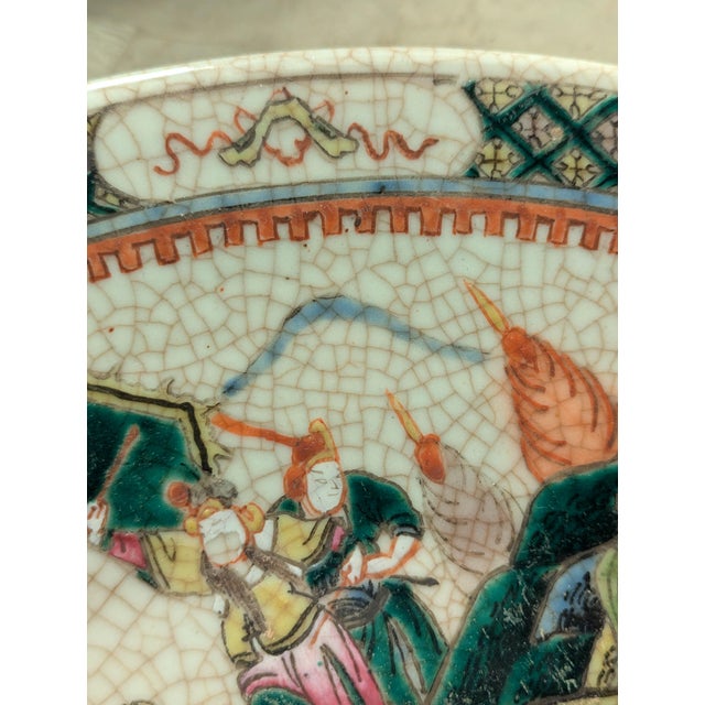 A striking antique Chinese porcelain charger decorated in the famille verte palette with an animated battle scene...