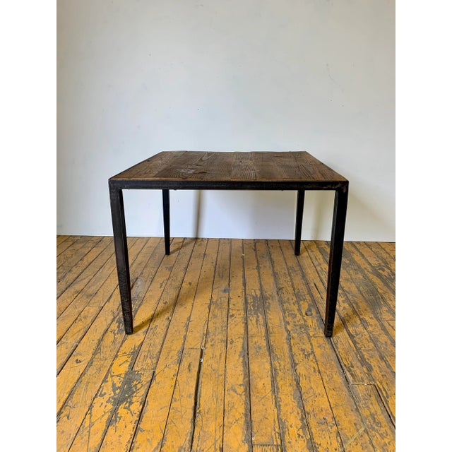Rustic modern square lamp table with wormy chestnut inset top. The base is wrought iron with tapered legs. The metal frame...