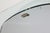 Thick curved glass mirror with mirror and wall mounting plate. Made by Fontana Arte, Milan, Italy. The back has a paper...