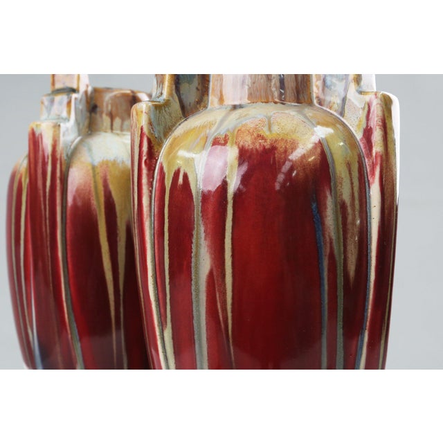 A striking pair of 1930s Belgian Art Deco ceramic vases, these pieces exemplify the bold color, expressive glazing, and...