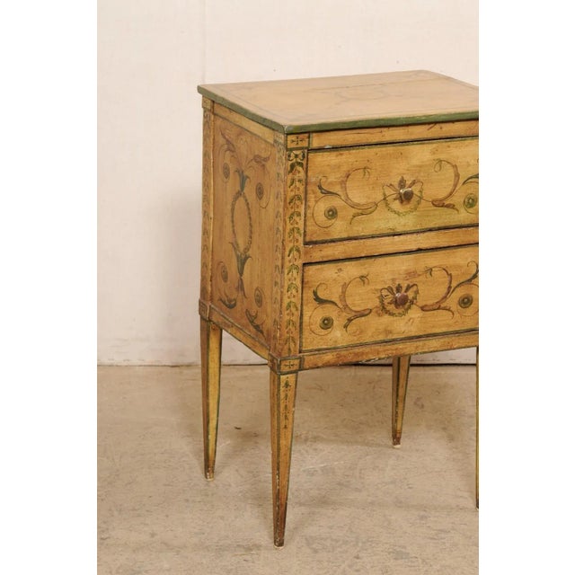 An Italian raised two-drawer painted wood side chest from the 19th century. This antique petite sized chest from Italy is...