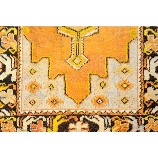 A vintage Turkish Oushak rug with a beautiful pattern woven in orange, gold, brown, and cream colored wool. The border is...