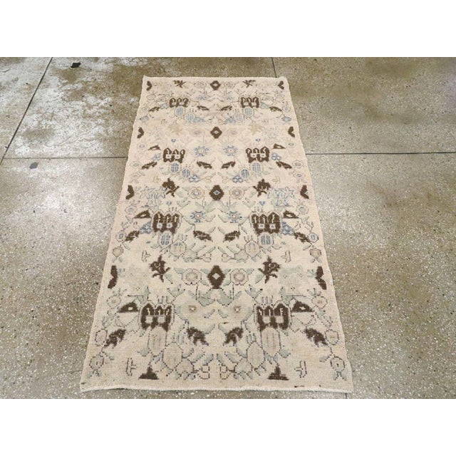 This mid-20th century Turkish Anatolian rug, measuring 2' 11" x 5' 11", features a delicate allover pattern composed of...