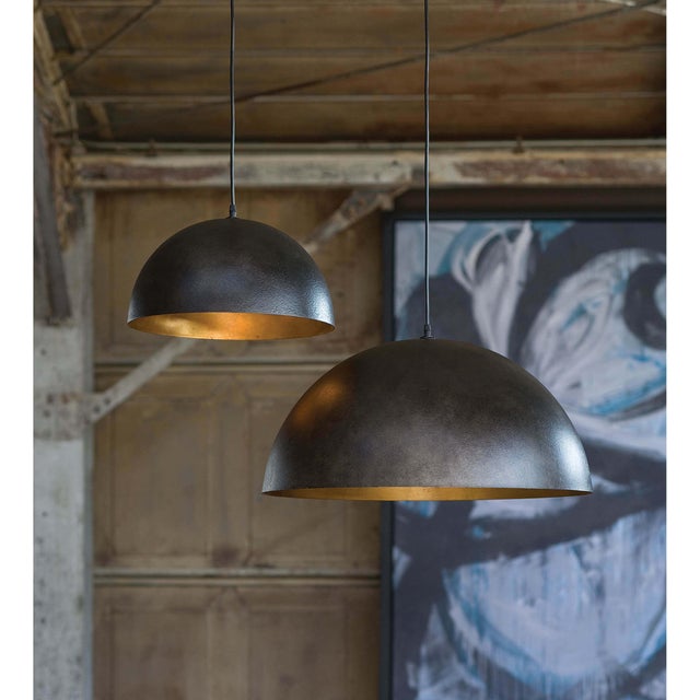 A simple dome shade brings sleek minimalism to the mix. Featuring a gold-leafed finish on the shade’s interior, this gives...
