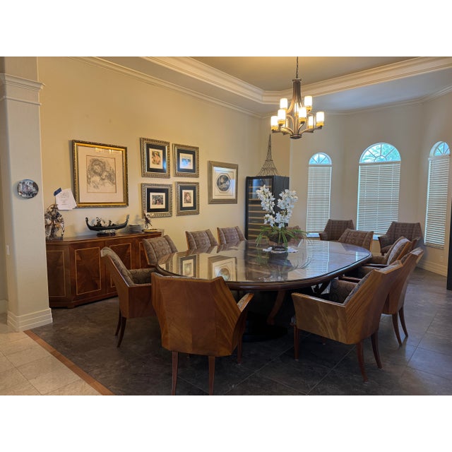 An exceptional handcrafted dining collection featuring a monumental expandable oval dining table acquired through a...